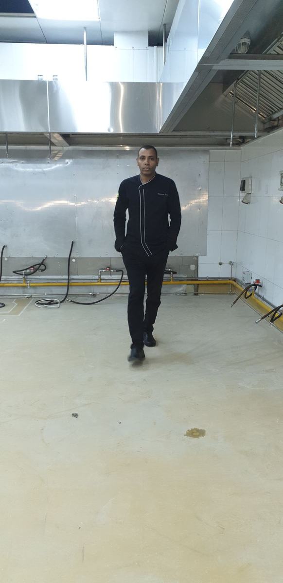 Chef Mohamed standing in an empty commercial kitchen during pre-opening