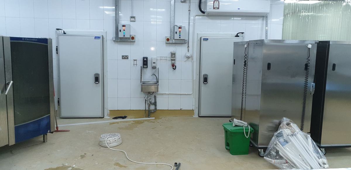 Cold room doors and wrapped equipment in a kitchen under construction