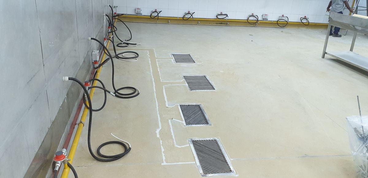 Floor drains and service lines laid out across a new kitchen